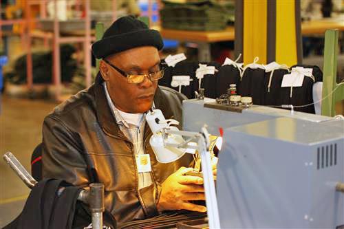 David Marshall sits at his sewing machine on the AIB production floor as he manufacturers a necktie. 