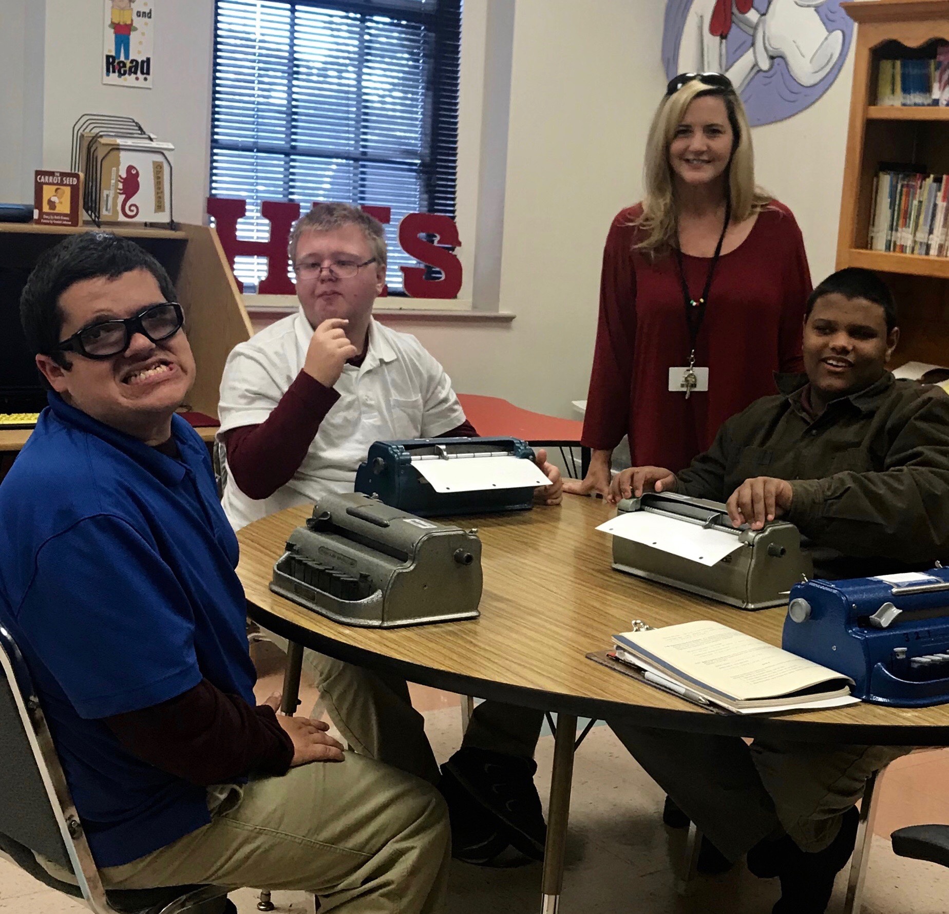Three male students participating in a braille lesson during a reading enrichment class. 