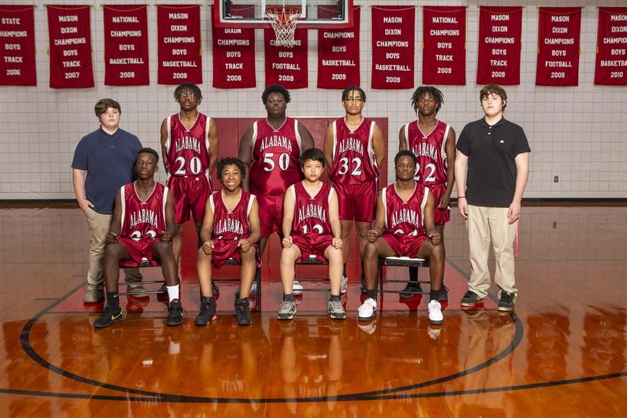 Members of the 2021-22 ASD boys junior high basketball team pose for the team photo in the gym.