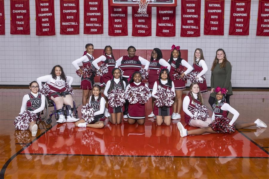 Cheerleaders side by side in the gym for the team photo
