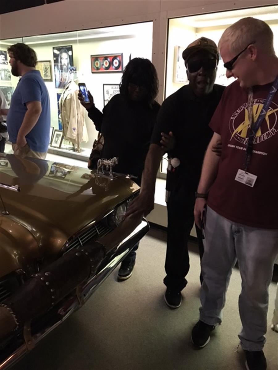 Four people in an auto museum. 