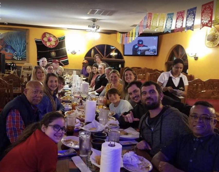 Picture of students and Deaf individuals from the community sitting at a table in a Mexican restaurant with instructor Lee Stoutamire.